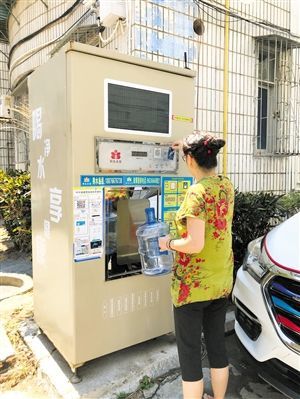 5月24日，琼山区上丹花苑小区居民陈女士在使用共享净水机取水。 本报记者 陈歆卓 摄